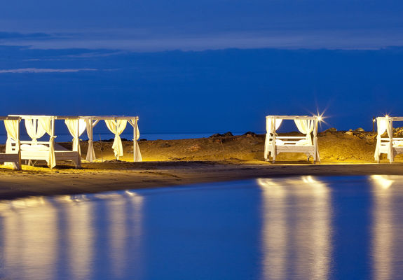 Knossos Beach Swell Restaurant gazebos lit up at night time