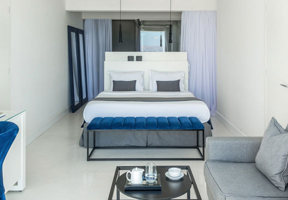 Knossos Beach Two Bedroom Suite Water Front Private Pool bedroom with double bed, couch and amenities