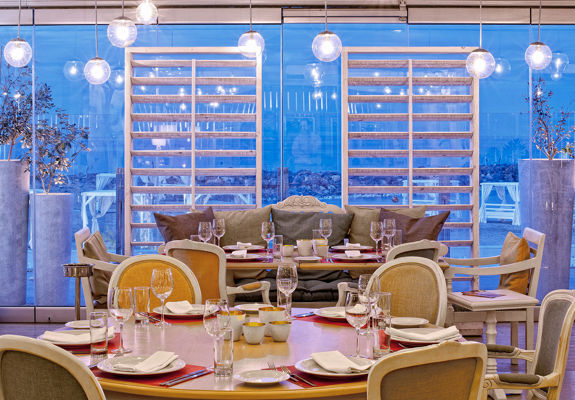 Knossos Beach Swell Restaurant indoor sitting area with big table and big couch