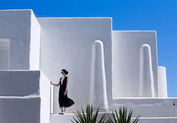 Knossos Beach visitor posing in front of the hotel's white walls