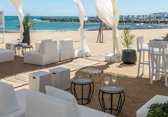 Knossos Beach Beach Life Restaurant tall table and couches next to the beach