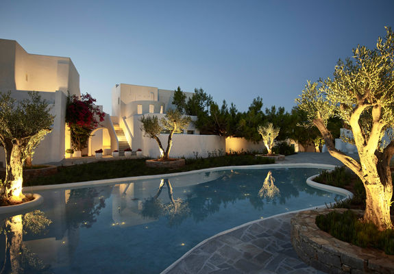 Knossos Beach garden lit up at night time with a pool in the middle
