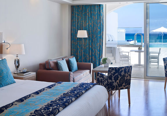 Knossos Beach Two Bedroom Spa Suite Water Front Private Pool double bed, couch, armchairs and terrace view