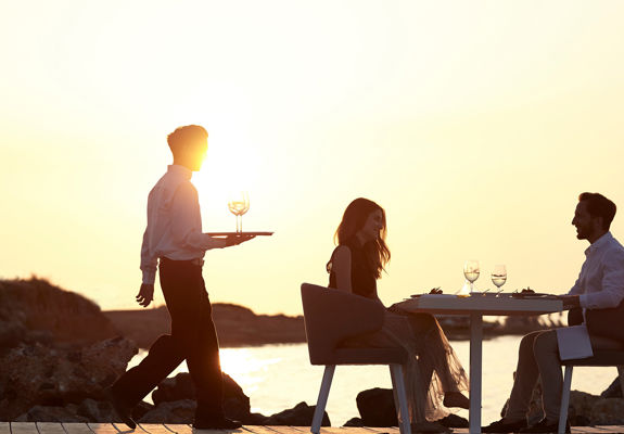 Knossos Beach Private Dining couple and the waiter serving them