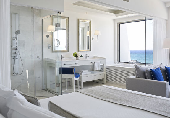 Knossos Beach Two Bedroom Suite Water Front double bed, the shower and the washbasin