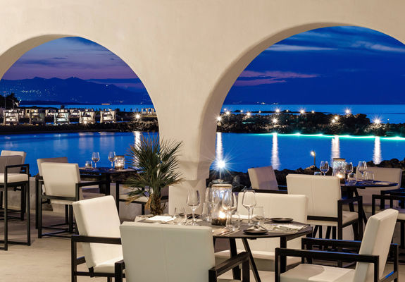 Knossos Beach Si La Restaurant sitting area lit up at night time