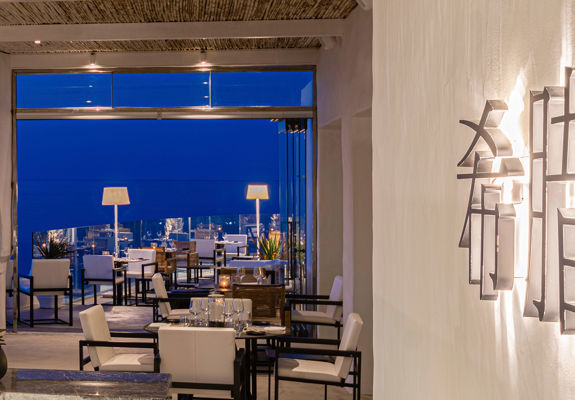 Knossos Beach Si La Restaurant sitting area and decorations lit up at night time