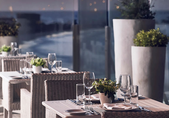Knossos Beach Swell Restaurant outdoor tables for two with sea view